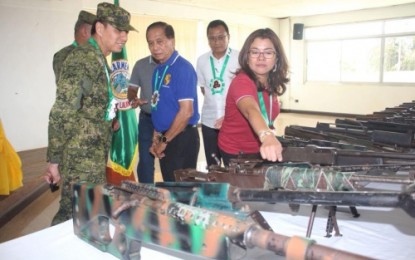 <p><strong>TURNOVER.</strong> North Cotabato Governor Emmylou Taliño–Mendoza checks one of the 102 loose firearms turned over on Thursday (April 19) by civilians in Carmen, North Cotabato. Looking on is Office of the Presidential Assistant on the Peace Process Secretary Jesus Dureza (in blue shirt). <em><strong>(Photo by 6ID – CMO)</strong></em></p>